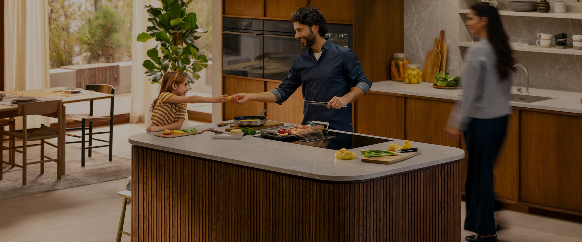 Une famille prépare le dîner ensemble dans une cuisine moderne avec des appareils de cuisine Electrolux